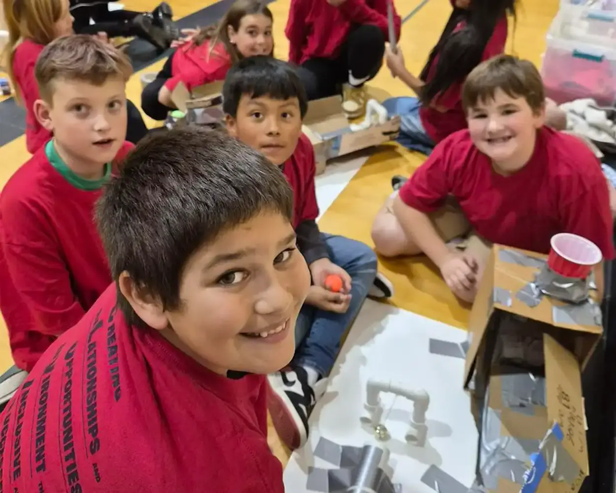 Eastmont school students building a science project on the floor of their gym